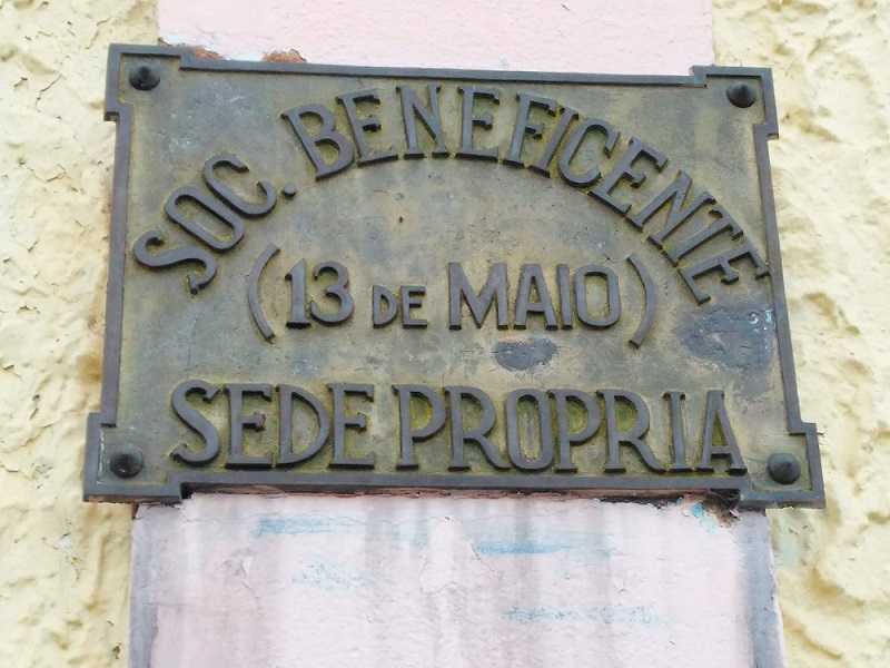 2. Placa de identificação da Sociedade Beneficente 13 de Maio, localizada na fachada da sede do clube.